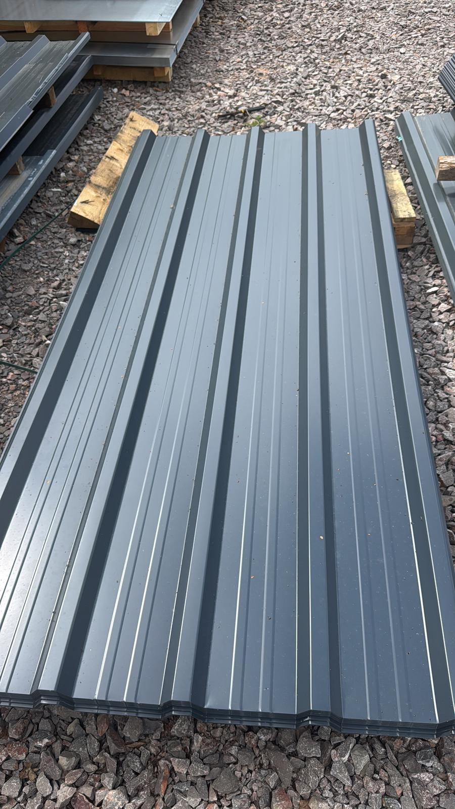 Anthracite polyester coated 32/1000 roofing sheets stacked on gravel